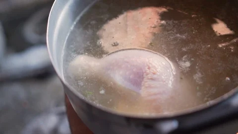 Old lady add another chicken thigh to a boil soup pot. Stock Footage 111467226