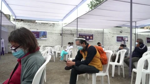 An old lady and her son resting after their covid-19 vaccination watching their 库存影片 156307125