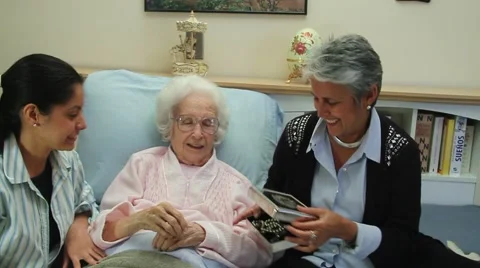Old lady in bed opens coffer, gives pearl neckless to younger female companion Stock Footage 45525048