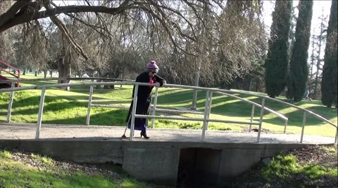 Old Lady With Cane Standing and Walking On Park bridge Stock Footage 59971961