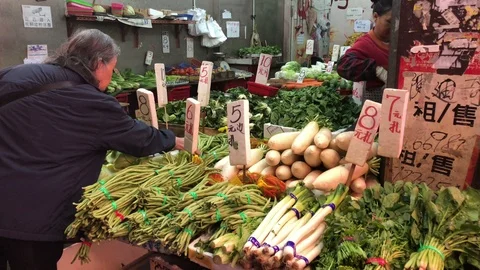 Old lady choosing the vegetable at the local market, Hong Kong, China Видео 89566043