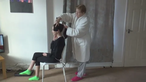 An old lady does her granddaughters hair Stock Footage 85601268