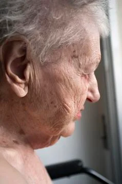 Old lady looking out window Stock Photos