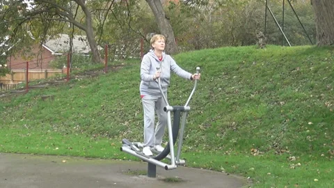 Old lady on an outside training apparatus Stock Footage 89332964
