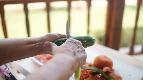 Old lady peeling cucumber Stock Footage 124270469