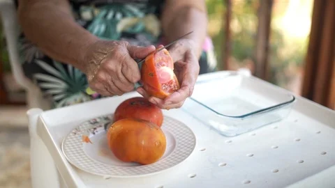 Old lady peeling tomatoes Stock Footage 124260058