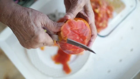 Old lady peeling tomatoes Stock Footage 124260266