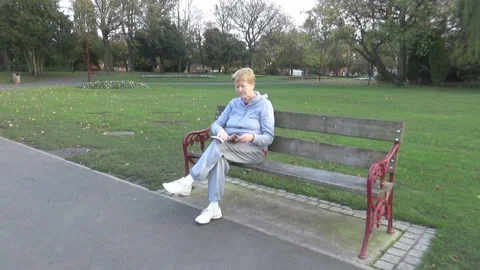 An old lady reading in park Stock Footage 85601729