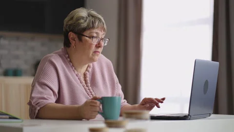 Old lady is sending message in chat in social net by laptop, surfing internet Stock Footage 153516473