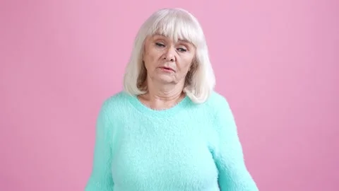 Old lady shrug shoulders not know decision isolated pastel color background Stock Footage