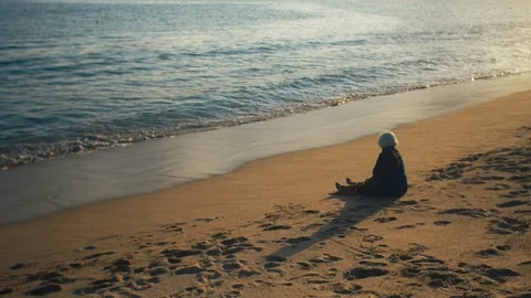 Old lady sitting on sandy beach Stock Footage 119114587
