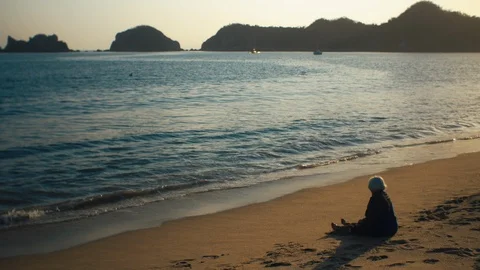 Old lady sitting on sandy beach Stock Footage 119120555