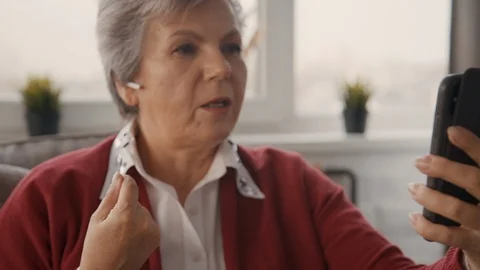 Old lady speaking with friends using her cellular Vídeos de archivo 108320111