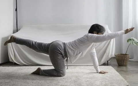 Old lady stand exercise by doing Yoga pose at living room Foto stock
