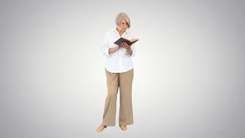 Old lady standing and reading a book on ... | Stock Video | Pond5