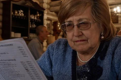 The old lady studies the menu. Stock Photos