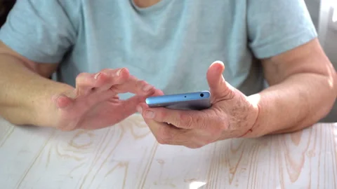 Old lady try to use smartphone with touchscreen, elderly woman's hands scrolling Stock Footage 134028304