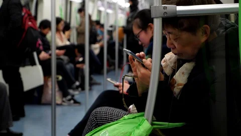 Old lady using smartphone during subway ride, slow motion shot Stock Footage 103867009