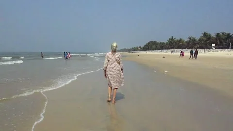 Old lady walking by the beach Stock Footage 154328585