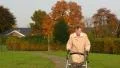 Old lady walking with wheel walker in autumn park  4k or 4k+ Resolution