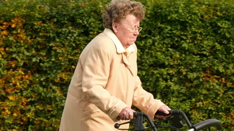 Old lady walking with wheel walker in autumn park  스톡 동영상 57341381