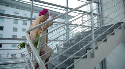 Old lady walks up the stairs Stock Footage 34649141