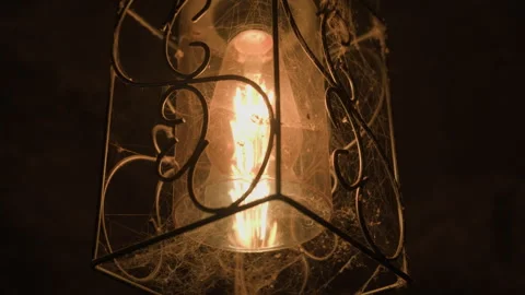 Old lamp in cobweb shines in dungeon Stock Footage 292308963