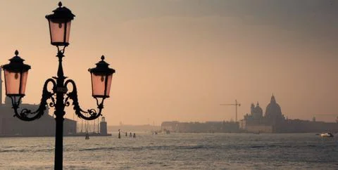 Old lamp post overlooking Venice lagoon at sunset Stock Photos