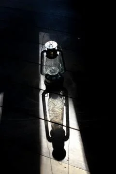Old lantern casts light in dark rustic room Photos