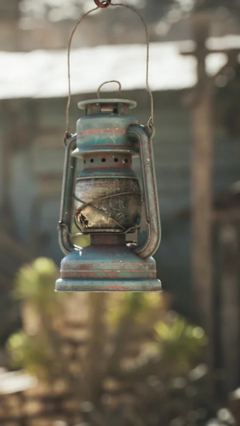 Old lantern hanging in a rustic outdoor area near a house at sunset Stock Footage 339766467