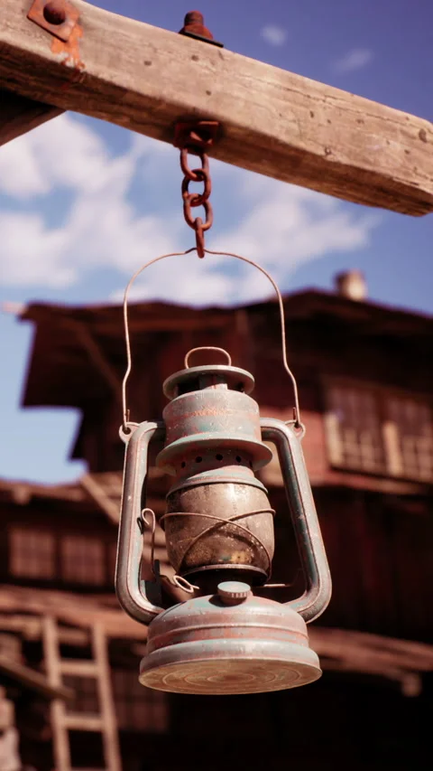 Old lantern hanging in rustic setting under clear blue sky Stock Footage 341048769