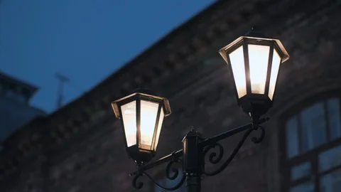 Old lantern that shines at night on the background of an old brick building. Stock Footage