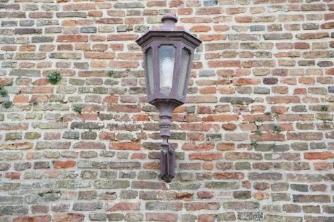Old lantern on a wall of red bricks Stock Photos