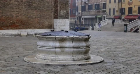 Old large closed stone water well in an empty square with a bridge Stock Footage 150391082