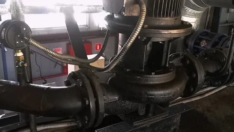 An old large electric pump on a heating pipe in a boiler room. Stock Footage 219502771