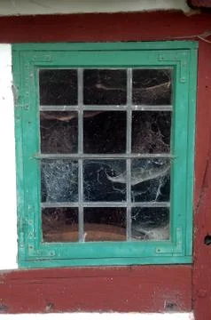 Old leaded window with cobwebs inside. Stock Photos