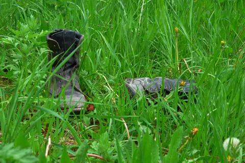 Old leather boots lying in grass Stock Photos