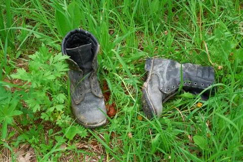 Old leather boots lying in grass Stock Photos