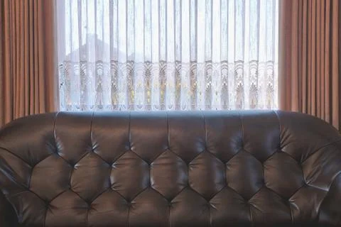 Old leather brown sofa near the window in vintage living room, antique retro  Stock Photos