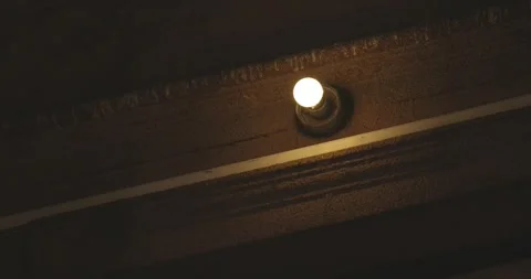 Old light bulb glowing in dark hallway Stock Footage 275344730