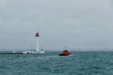 Old lighthouse against the background of clouds and the sea in the seaport of Od Stock Photos