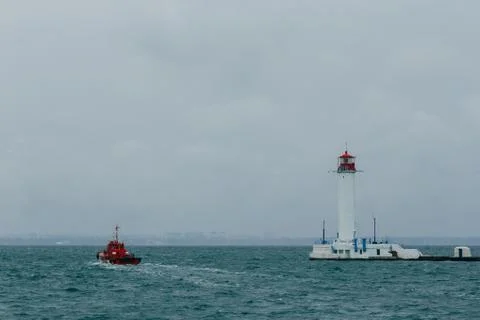 Old lighthouse against the background of clouds and the sea in the seaport of Od Stock Photos