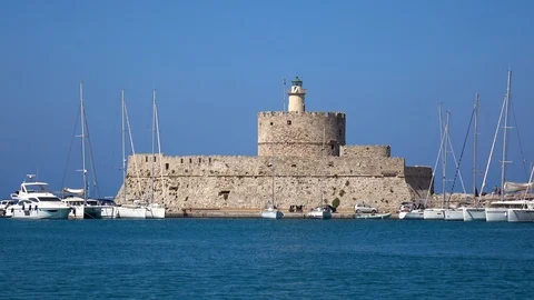 The old lighthouse and the medieval Saint Nicholas fort in the Mandraki port Stock Footage 95143842