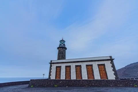Old lighthouse building under the clouds, long exposure Stock Photos