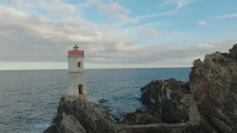 Old lighthouse on a cliff at sunset Stock Footage 230985576