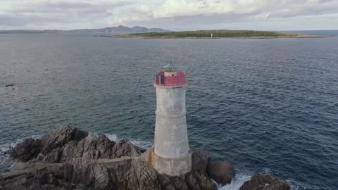 Old lighthouse on a cliff at sunset Stock Footage 230995157