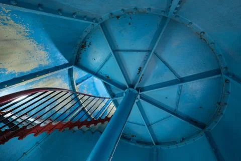 Old lighthouse on the inside. Red iron spiral stairs and blue wall. Kihnu, sm Stock Photos