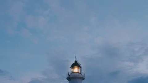 Old lighthouse is working at twilight on moody sky background Stock Footage 87175715