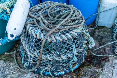 An old lobster pot and float at a harbour in Cornwall Stock Photos