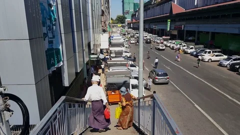 Old local couple walks down stairs, Yangon road, traffic, buildings, pedestrians Видео 77820030